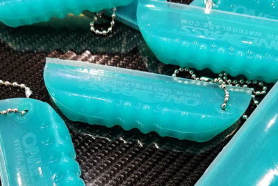 A small teal, finger-sized squeegee blade keychain